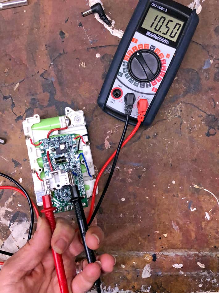 Checking the results of boosting a battery with a multimeter.