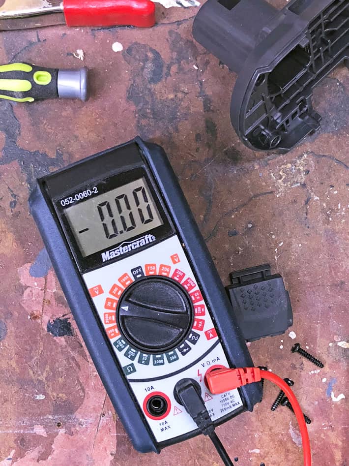 Multimeter on workbench with tools around.