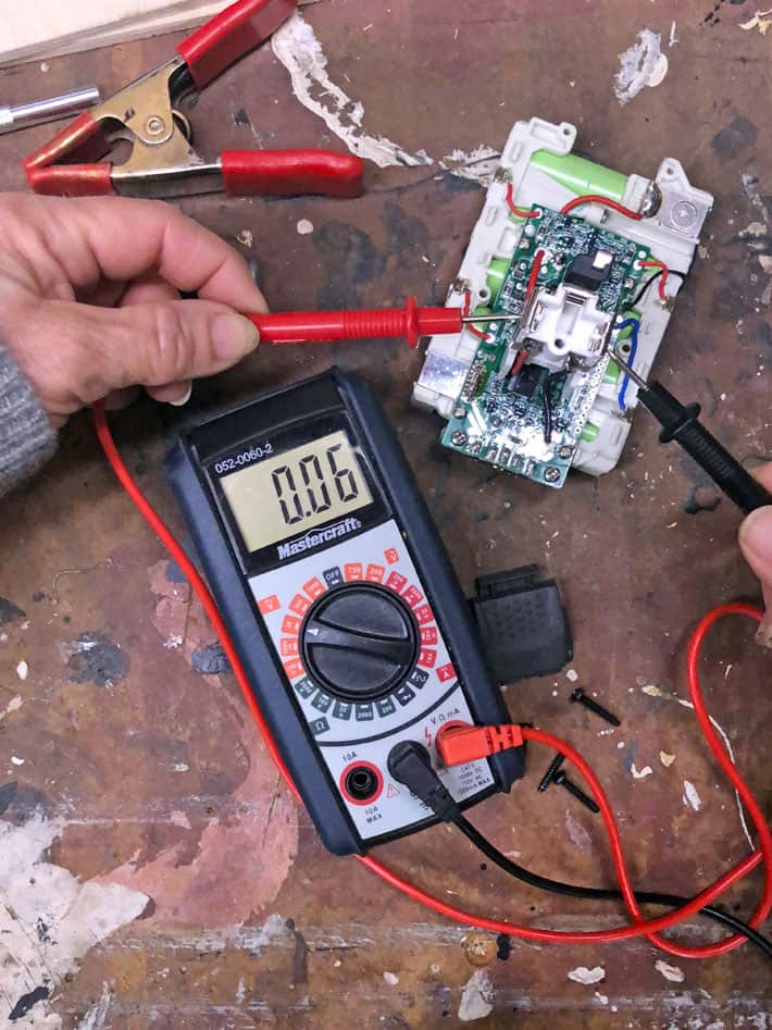 Testing 18 volt battery cell with multimeter with a reading of 0.06