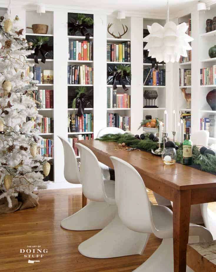 Dining room, library combination room with harvest table and white Panton S chairs decorated for Christmas.