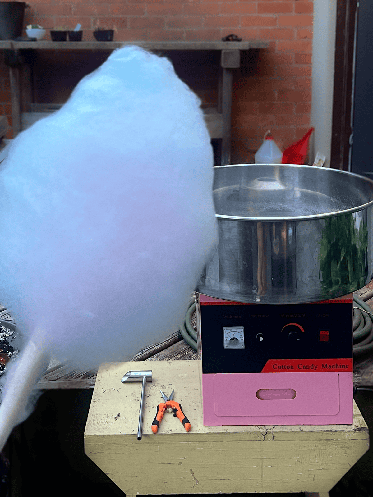 Homemade cotton candy with cotton candy machine in background.